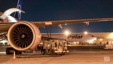 Night view of Polar Air cargo jet with view of an engine from another plane in the forefront.