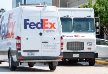 FedEx delivery vans are parked in a lot.