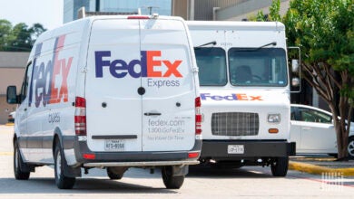 FedEx delivery vans are parked in a lot.