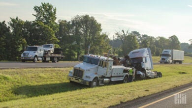 Semi-truck accident in a median, with a tow truck.