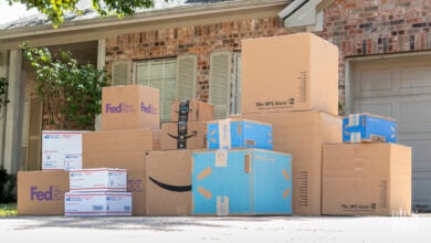 Amazon, FedEx, UPS, and U.S. Postal Services boxes stacked up in a homeowner's driveway.