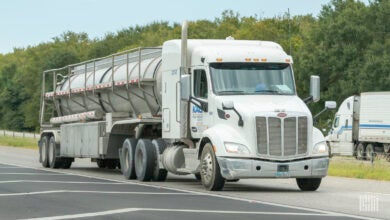 A KAG tractor pulling a tank trailer on a highway