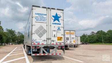 A Landstar trailer next to a Werner trailer in a parking lot