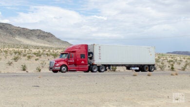 A maroon Knight Transportation tractor pulling a refrigerated Triton container