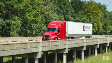 A red Knight sleeper cab pulling a Knight dryvan trailer