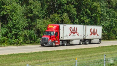 A red Saia tractor pulling two Saia pup trailers