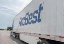 A sideview of an ArcBest trailer on a highway