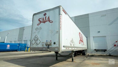 A white Saia trailer backed into a dock door