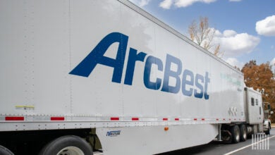 A white sleeper cab pulling a white ArcBest trailer