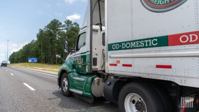 An Old Dominion tractor pulling a trailer on a highway