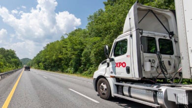 An XPO trailer pulling a daycab on a highway