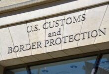 Engraved name of U.S. Customs and Border Protection over entrance door of building.