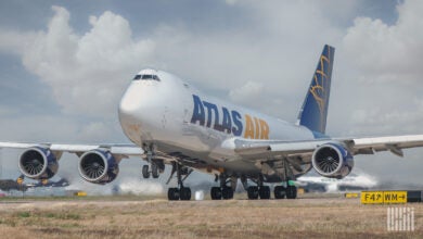 A massive Atlas Air jumbo jet begins to lift off runway.