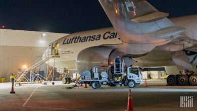 Night view of a tanker truck refueling a Lufthansa Cargo plane.