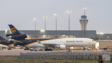 A brown-tailed UPS jet parked at an airport on a cloudy day.