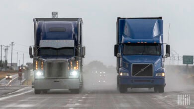 front view of two tractor-trailers on a rain-soaked highway