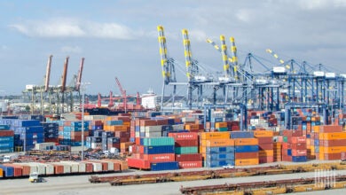 Image shows container cranes, containers and doublestack railroad cars at the Port of Los Angeles.