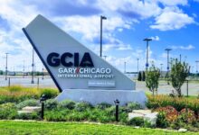 Entrance sign to Gary/Chicago International Airport with blue sky in background.