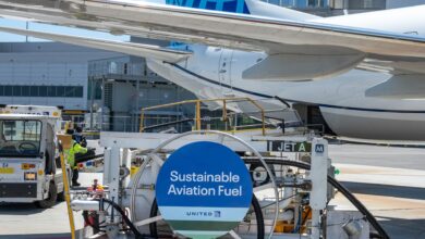 A jet being filled with sustainable aviation fuel at an airport. The fuel dolly has a blue SAF sign on it.