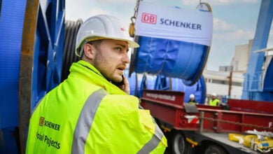 Image shows a Schenker worker and trailer with cargo.