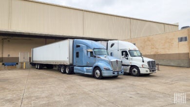 Two tractor-trailers being loaded at a warehouse