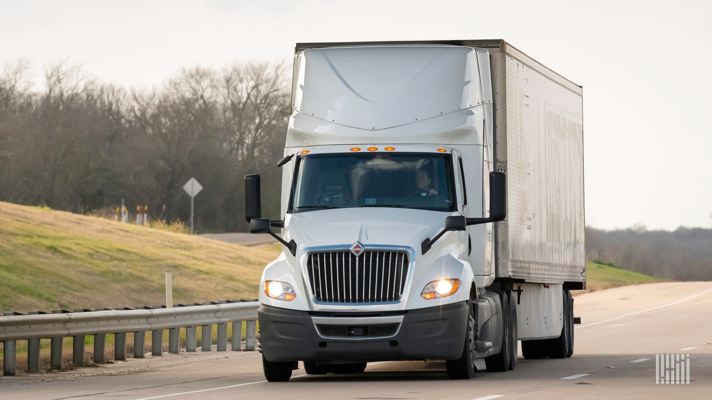 A white truck and trailer on highway