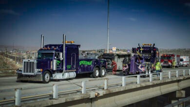 Wrecker towing a truck from crash site.