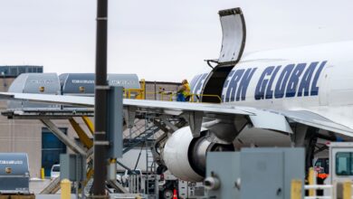 View from behind wing of containers being loaded in a Western Global freighter.